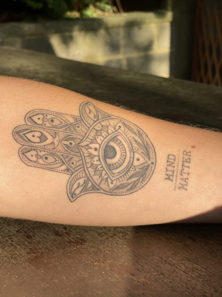 Detailed ornamental tattoo on a forearm featuring a hamsa tattoo design 